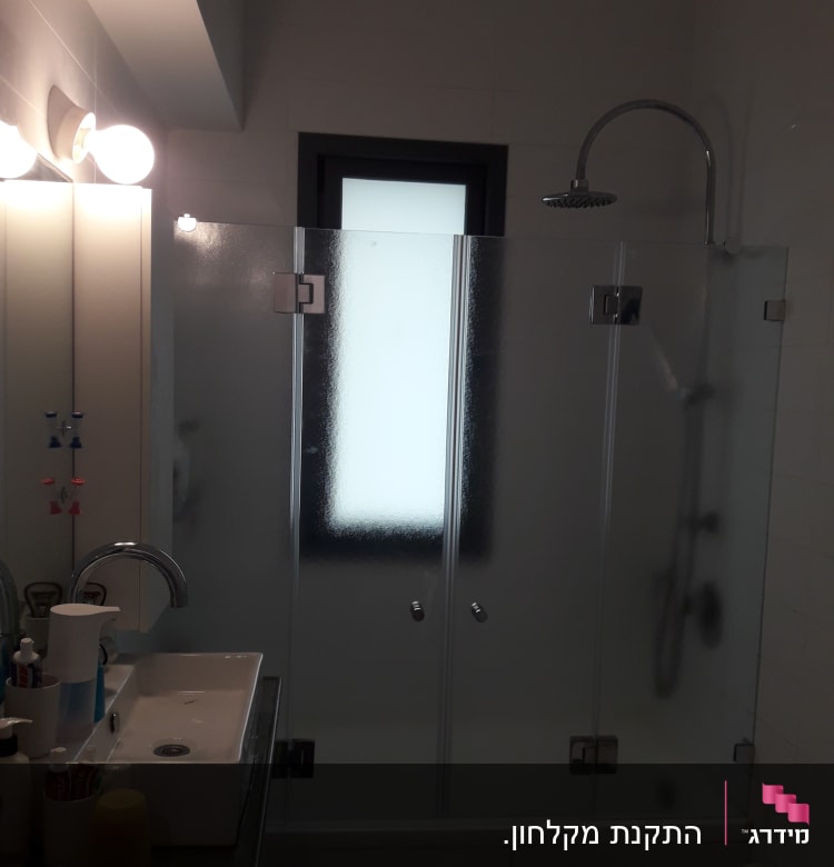 מקלחת עם דלתות זכוכית וברז מקלחת עגול